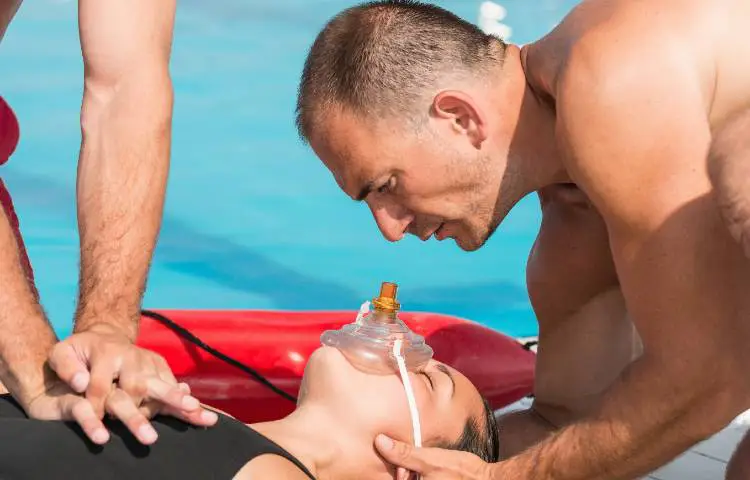 Lifeguard Giving Cpr To Drowning Victim Wearing Mask