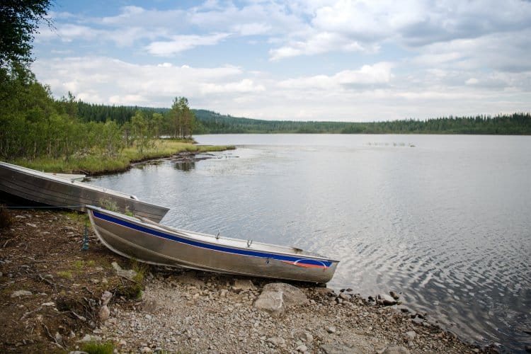 Metal Boats Moored On Shore Of Lake